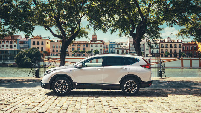 Pohľad zboka na vozidlo Honda CR-V Hybrid na ulici.