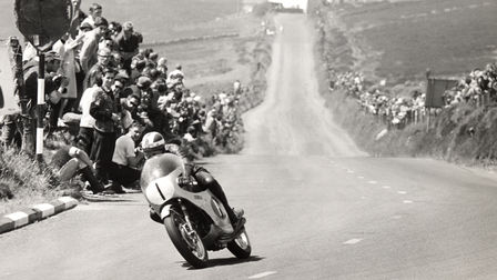 Trojštvrťový pohľad na motocykel Honda Fireblade na pretekárskej trati s jazdcom. Historický záber (exteriér).