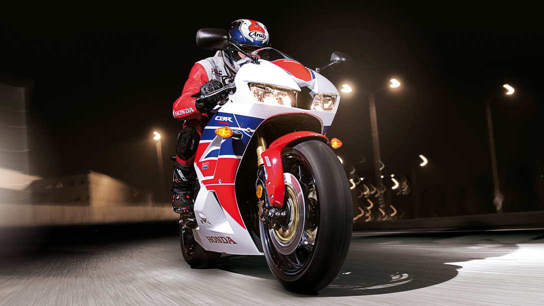 Predný 3/4 pohľad na model Honda CBR600RR s jazdcom. Pohľad sprava (na ceste).