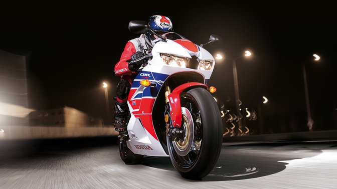Front three quarter view of Honda CBR600RR and rider in dark location.