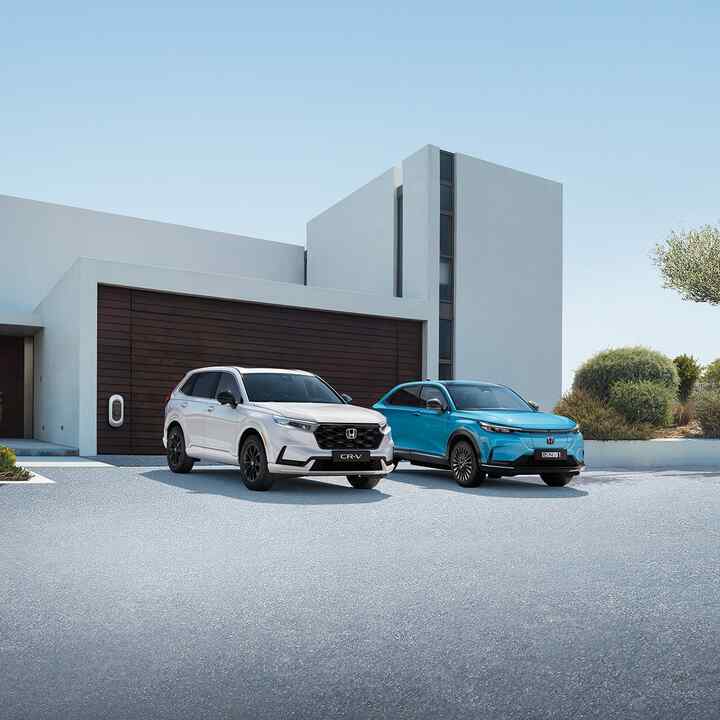 Ponuka hybridných vozidiel Honda zaparkovaných pred budovou.