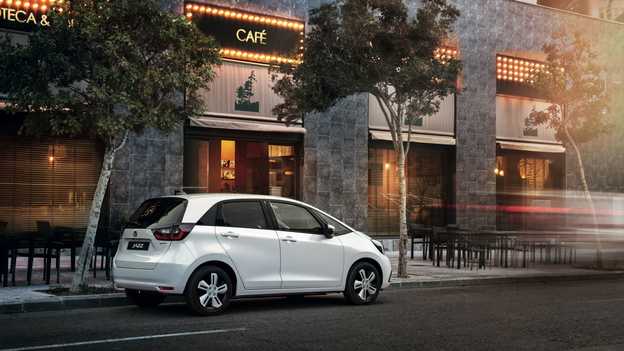 Pohľad zozadu na model Honda Jazz Hybrid zaparkovaný pred kaviarňou