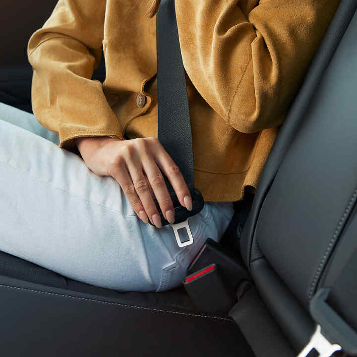 Osoba zapínajúca si bezpečnostný pás vo vnútri vozidla Honda Civic Hybrid.