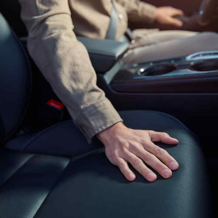 Detailný záber na osobu s rukou na sedadle vozidla Honda Civic Hybrid.