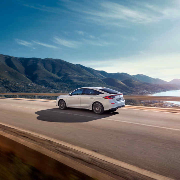 Honda Civic Hybrid v pohybe na diaľnici, s malebným výhľadom.