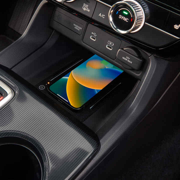 Detailný záber na bezdrôtovo nabíjaný telefón vo vnútri modelu Civic Hybrid.