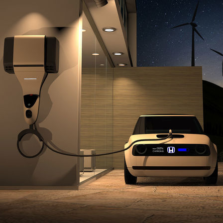 Pohľad spredu na model Honda Urban EV Concept pripojený k nabíjačke.