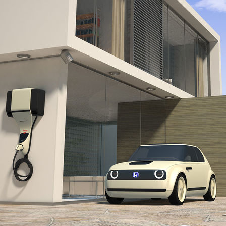 Predný trojštvrťový pohľad na model Honda Urban EV Concept s nabíjacou stanicou.