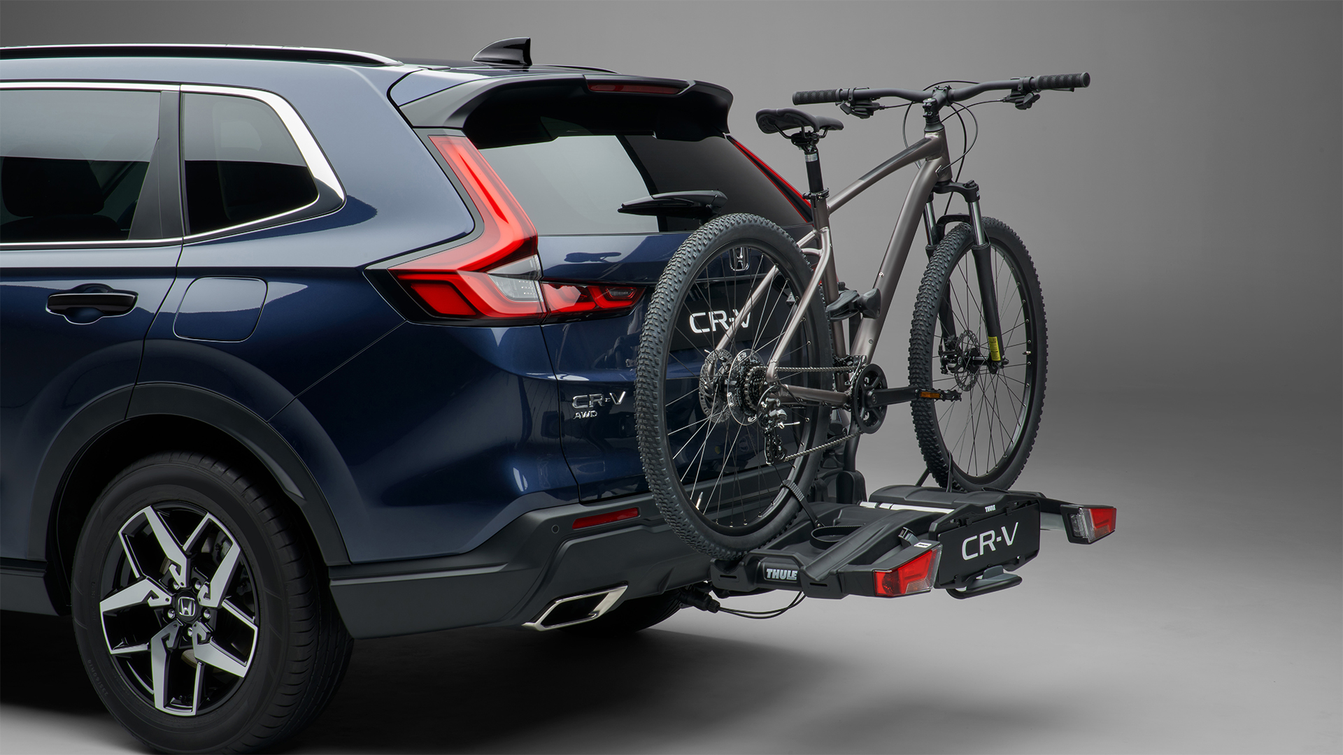 Zadný trojštvrťový pohľad na model Honda CR-V Hybrid s nosičom na bicykle.