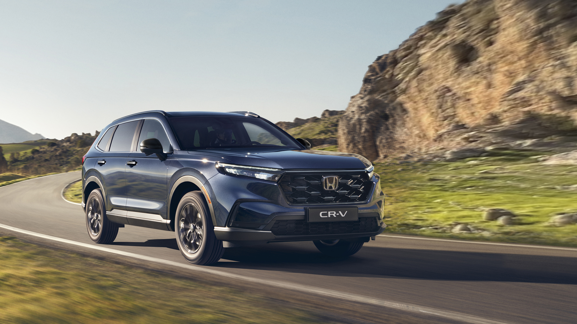 Trojštvrťový pohľad spredu na vozidlo Honda CR-V Hybrid pri jazde v horách.
