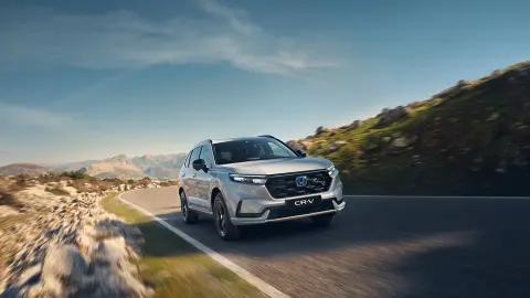 Pohľad spredu na model CR-V Hybrid SUV pri jazde v horách.