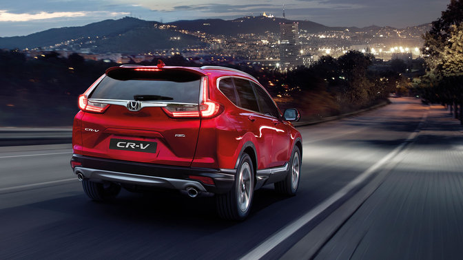 Trojštvrťový pohľad zozadu na model CR-V na horskej ceste.