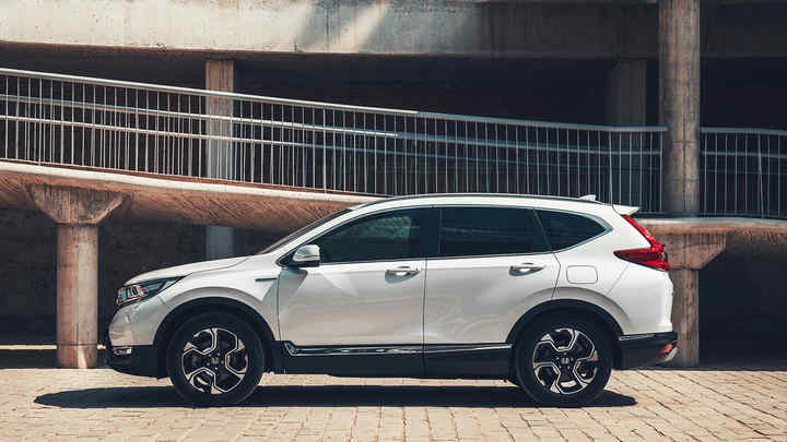 Pohľad zboku na vozidlo Honda CR-V Hybrid na ulici.