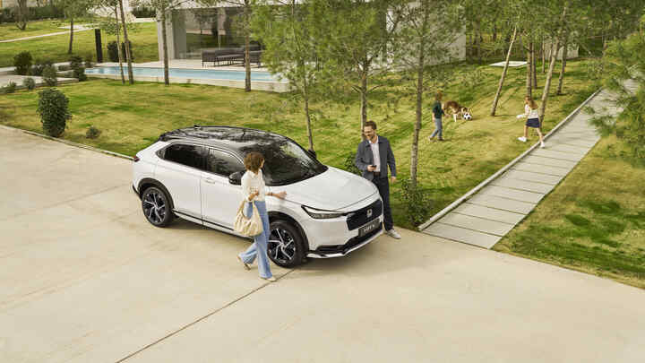 Bočný pohľad na vozidlo Honda HR-V e:HEV na príjazdovej ceste