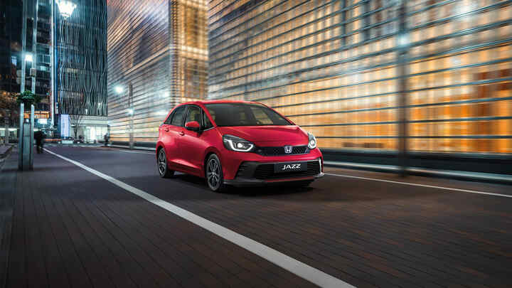 Trojštvrťový pohľad spredu na vozidlo Honda Jazz s mestským pozadím.