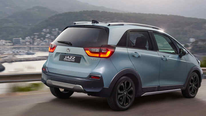 Pohľad zozadu na Hondu Jazz Crosstar jazdiacu v pobrežnej oblasti. 
