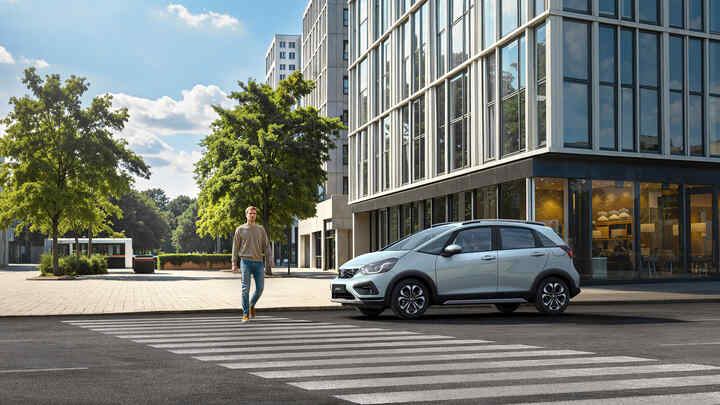 Dve vozidlá Honda Jazz zaparkované pred kancelárskou budovou.