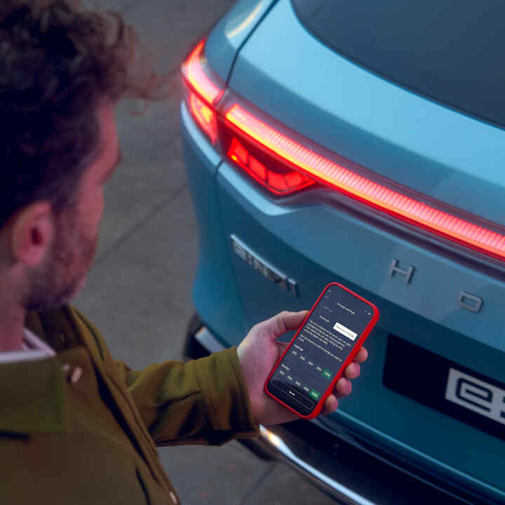 Detailný záber na aplikáciu My Honda+ osoby používajúcej telefón mimo vozidla