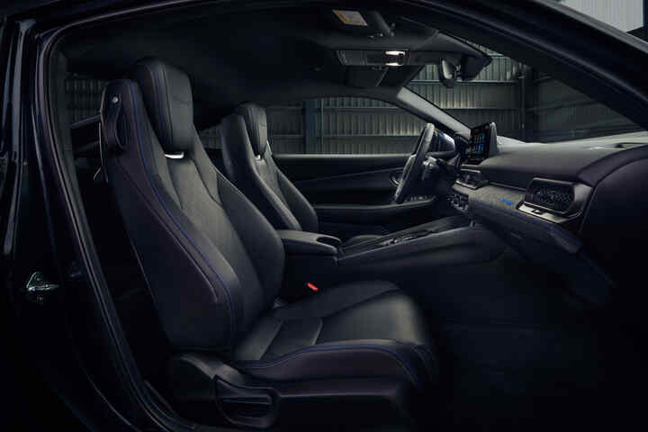 Pohľad do interiéru modelu Honda Prelude Hybrid s čiernymi koženými sedadlami s modrým prešívaním a modernou palubnou doskou.