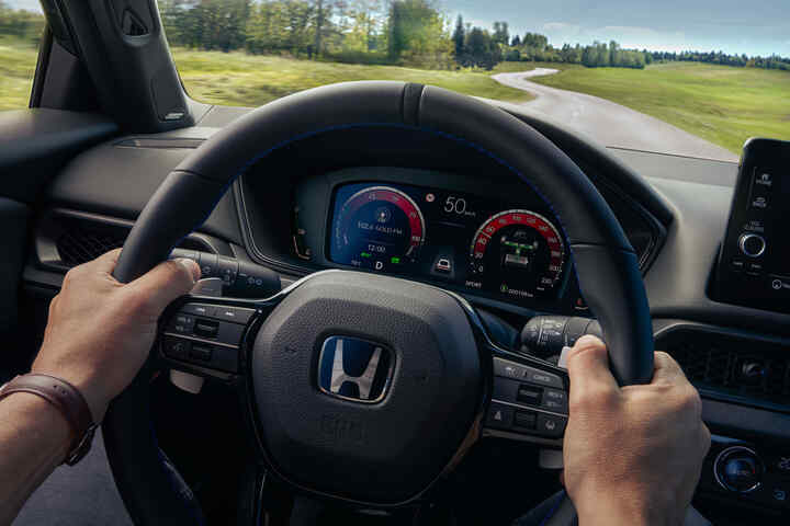 Vodič si užíva interiér modelu Honda Prelude Hybrid s digitálnym kokpitom a pokročilým informačno-zábavným systémom.