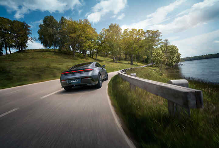 Honda Prelude Hybrid pri jazde po malebnej ceste popri jazere s horami v pozadí.