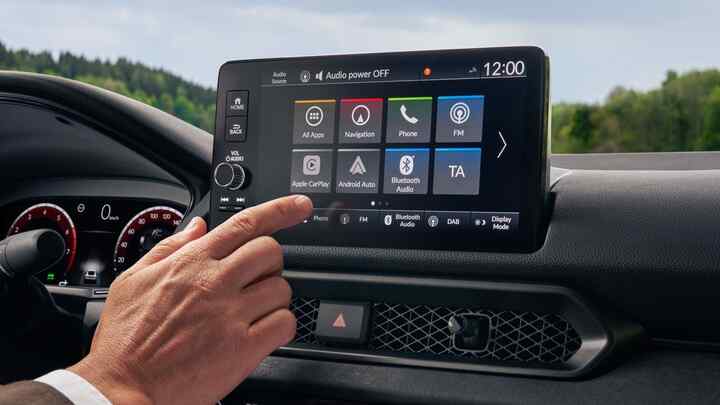 Ruka sa pohybuje, aby sa dotkla obrazovky multimediálneho systému vozidla Prelude Hybrid.