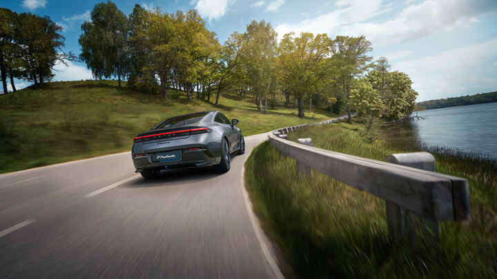 Pohľad zozadu na Hondu Prelude Hybrid idúcu po diaľnici vedľa jazera.