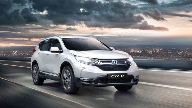 Predný trojštvrťový pohľad na model Honda CR-V so zapnutými diaľkovými svetlami
