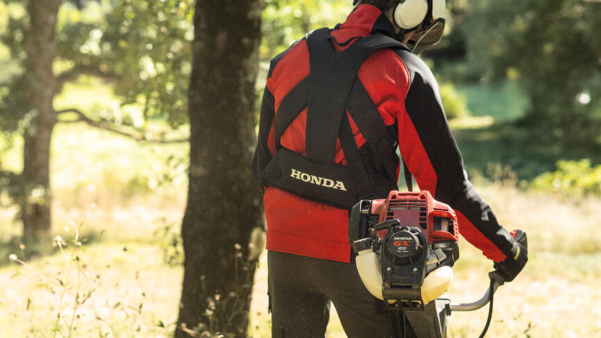 Figurant v lese s krovinorezom na chrbte.