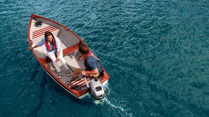 Muž a žena v člne používajúci motor BF2.3 na pohon člnu vpred