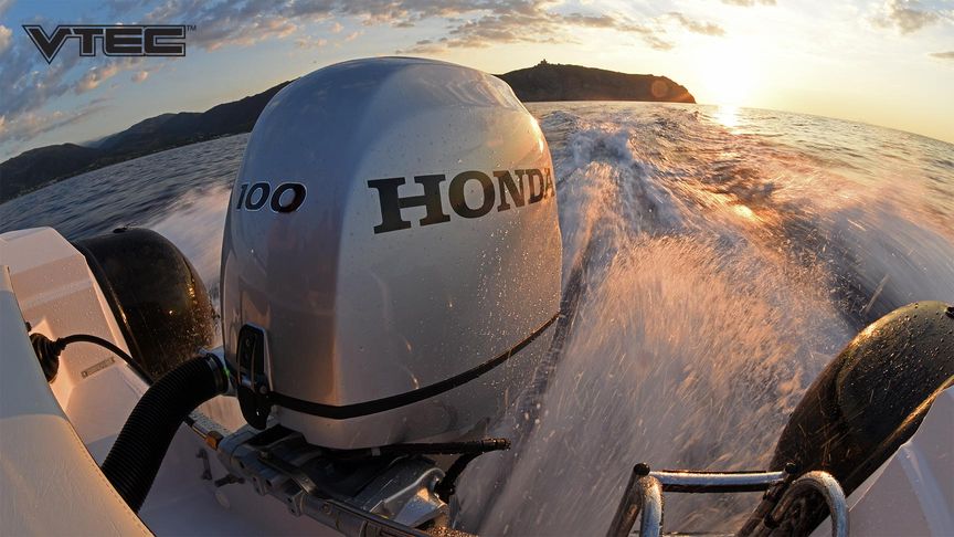 Pohľad zozadu na pohybujúci sa čln so závesným motorom Honda BF 100 pri západe slnka
