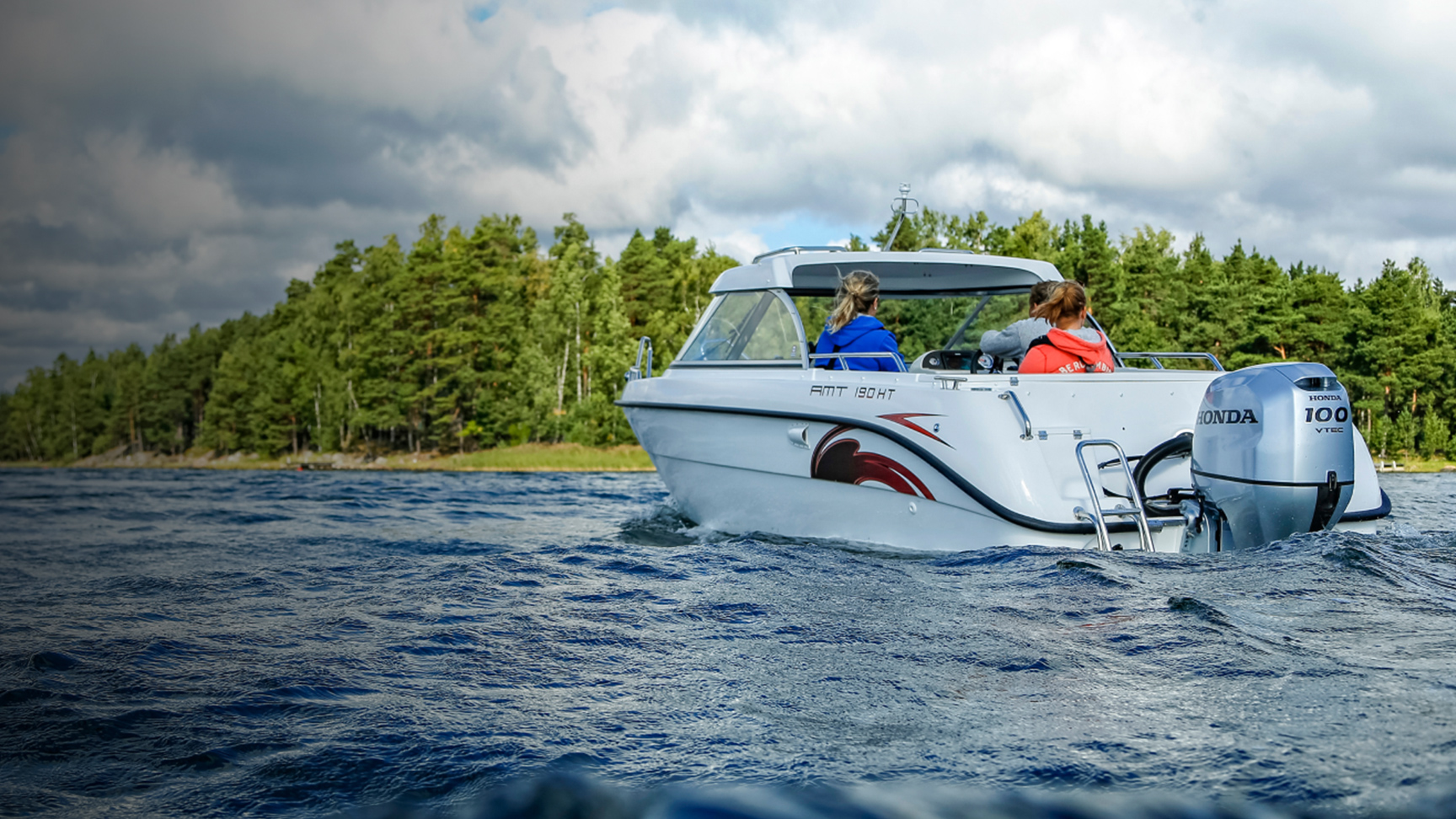 Rodina na lodi na jazere s motorom Honda BF80-100. 