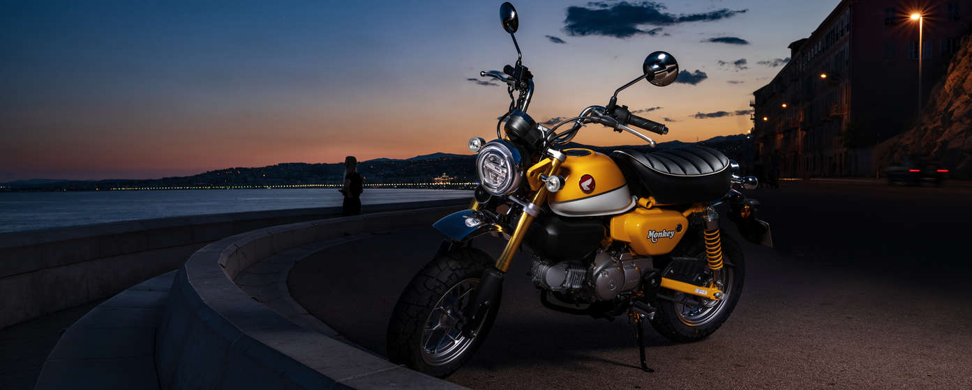 Honda Monkey zaparkovaná na pláži.