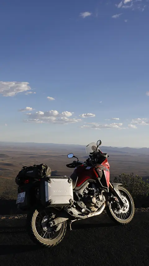 Motocykel Honda CRF1000L Africa Twin zaparkovaný na ceste s výhľadom na púšť Karoo.