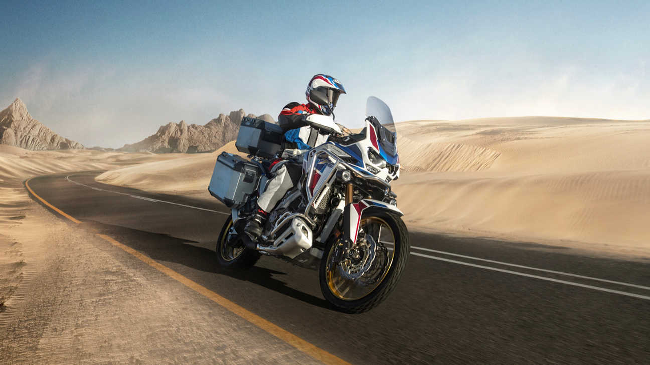 Honda Africa Twin Adventure Sports, trojštvrťový záber spredu z ľavej strany, jazda po ceste v púšti