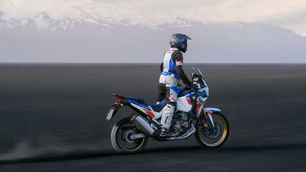 Zadný trojštvrťový pohľad na motocykel Honda Africa Twin pri jazde dunami.