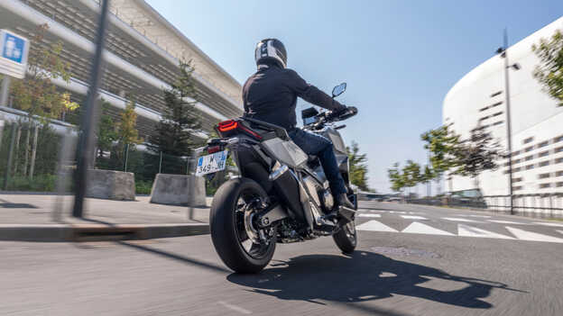 Pohľad zozadu na motocykel Honda X-ADV pri jazde mestom.