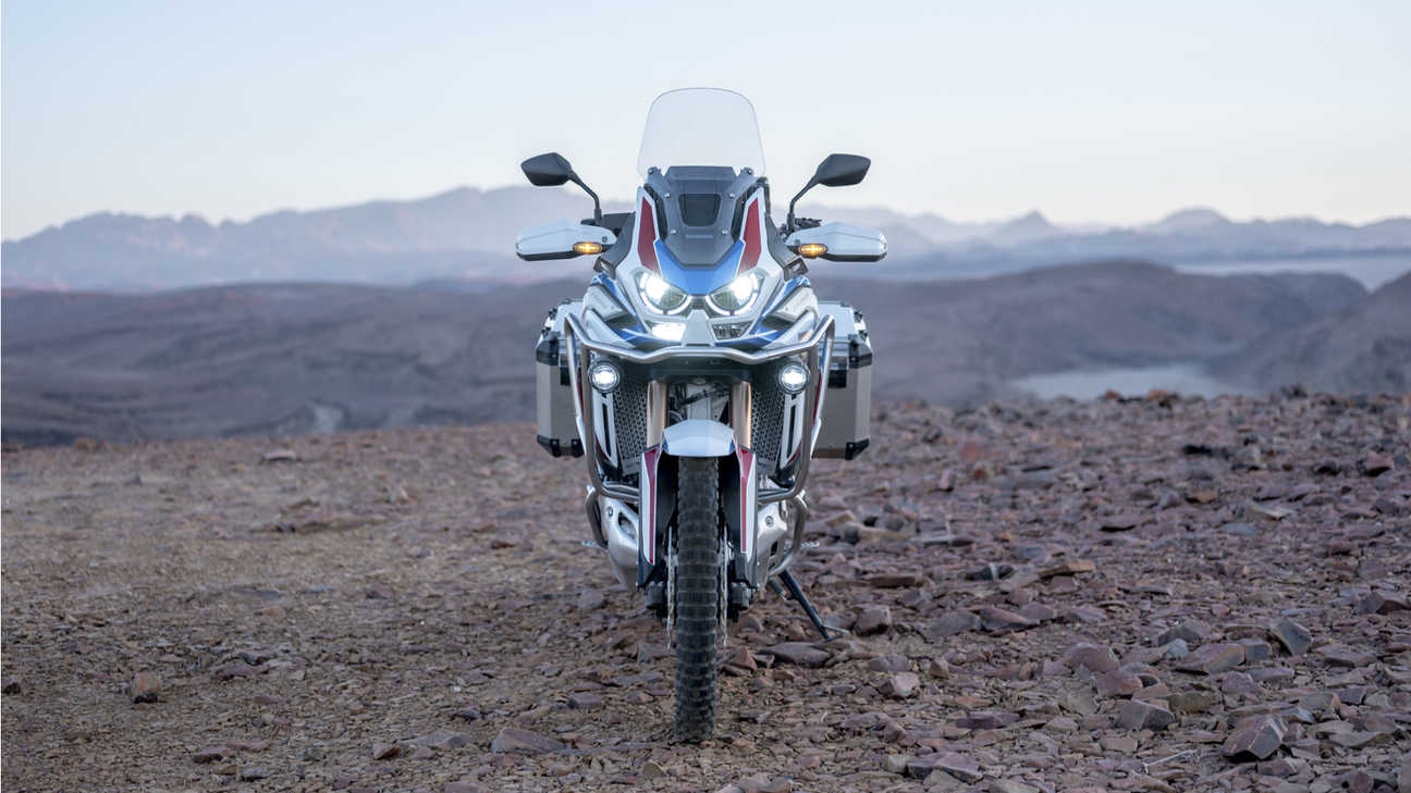 Záber spredu na model Honda Africa Twin Adventure Sports so zapnutými svetlami
