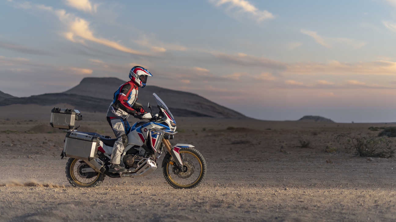 Pohľad sprava na model Honda Africa Twin Adventure Sports pri jazde púšťou po prašnej ceste