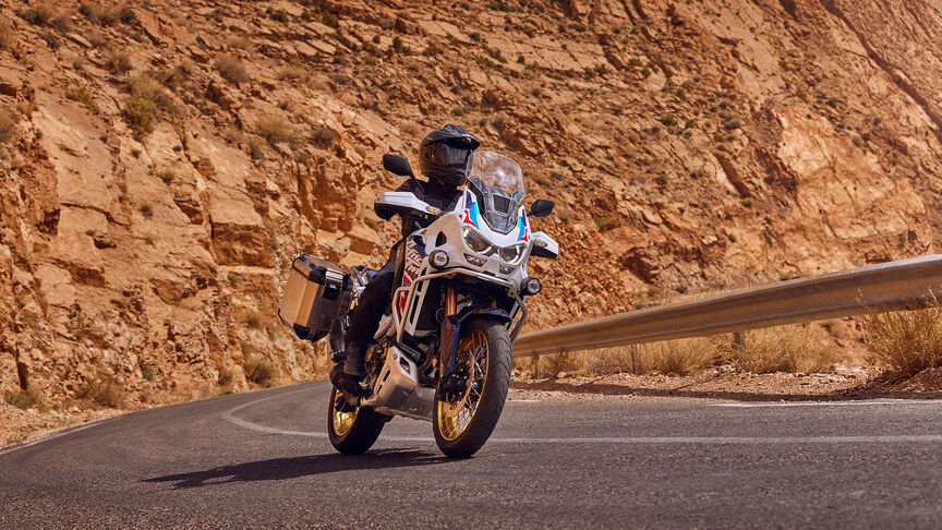 Predný trojštvrťový záber na motocykel Honda CRF1100 Africa Twin Adventure Sports v horskej oblasti.