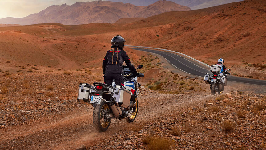 Predný trojštvrťový záber na motocykel Honda CRF1100 Africa Twin Adventure Sports v horskej oblasti.