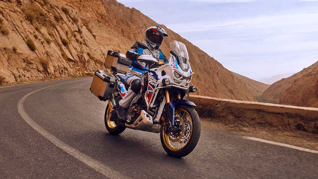 Záber spredu na jazdca na motocykli Honda CRF1100 Africa Twin Adventure Sports v púšti.