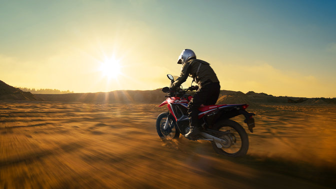 Trojštvrťový pohľad na model Honda CRF250 Rally s jazdcom zľava