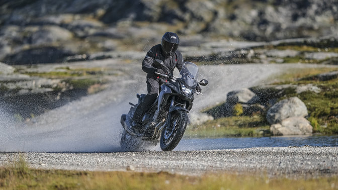 Model Honda CB500X pri jazde cez vodu.