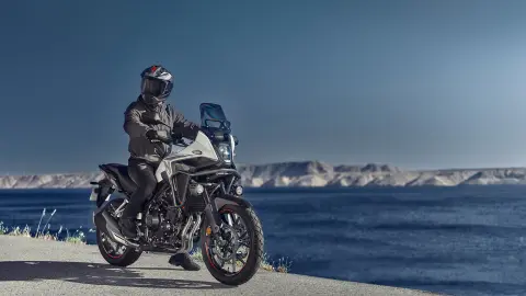 Stojaca Honda NX500 s jazdcom na pobreží