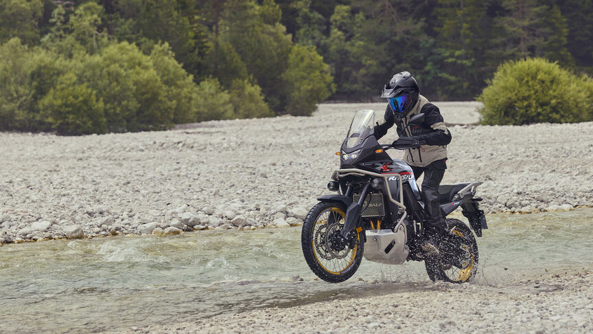 Figurant pri jazde na motocykli XL750 Transalp v lese.