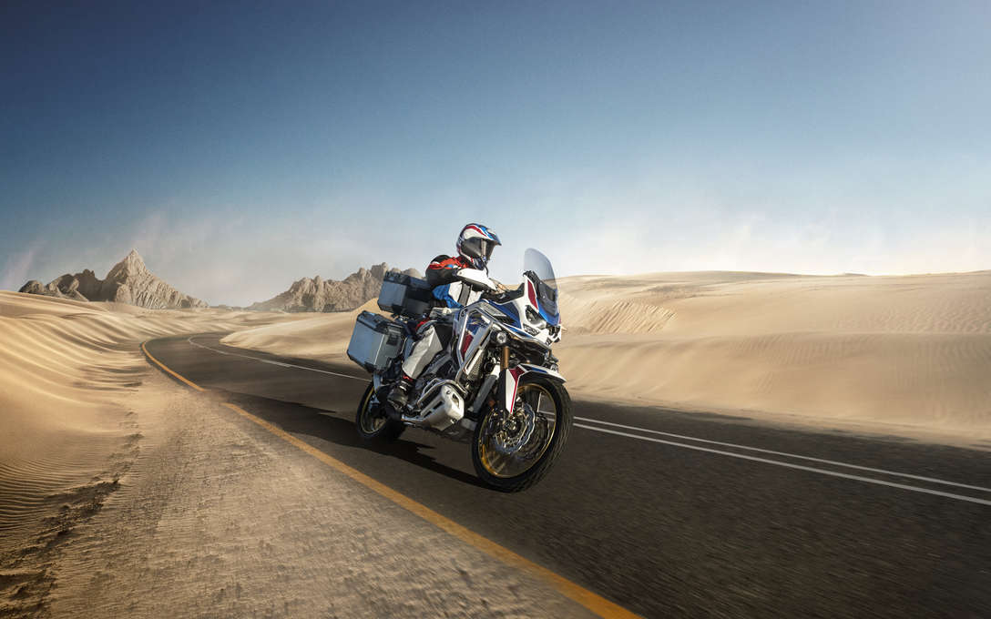 Honda Africa Twin Adventure Sports, trojštvrťový záber spredu z pravej strany, jazda po ceste v púšti