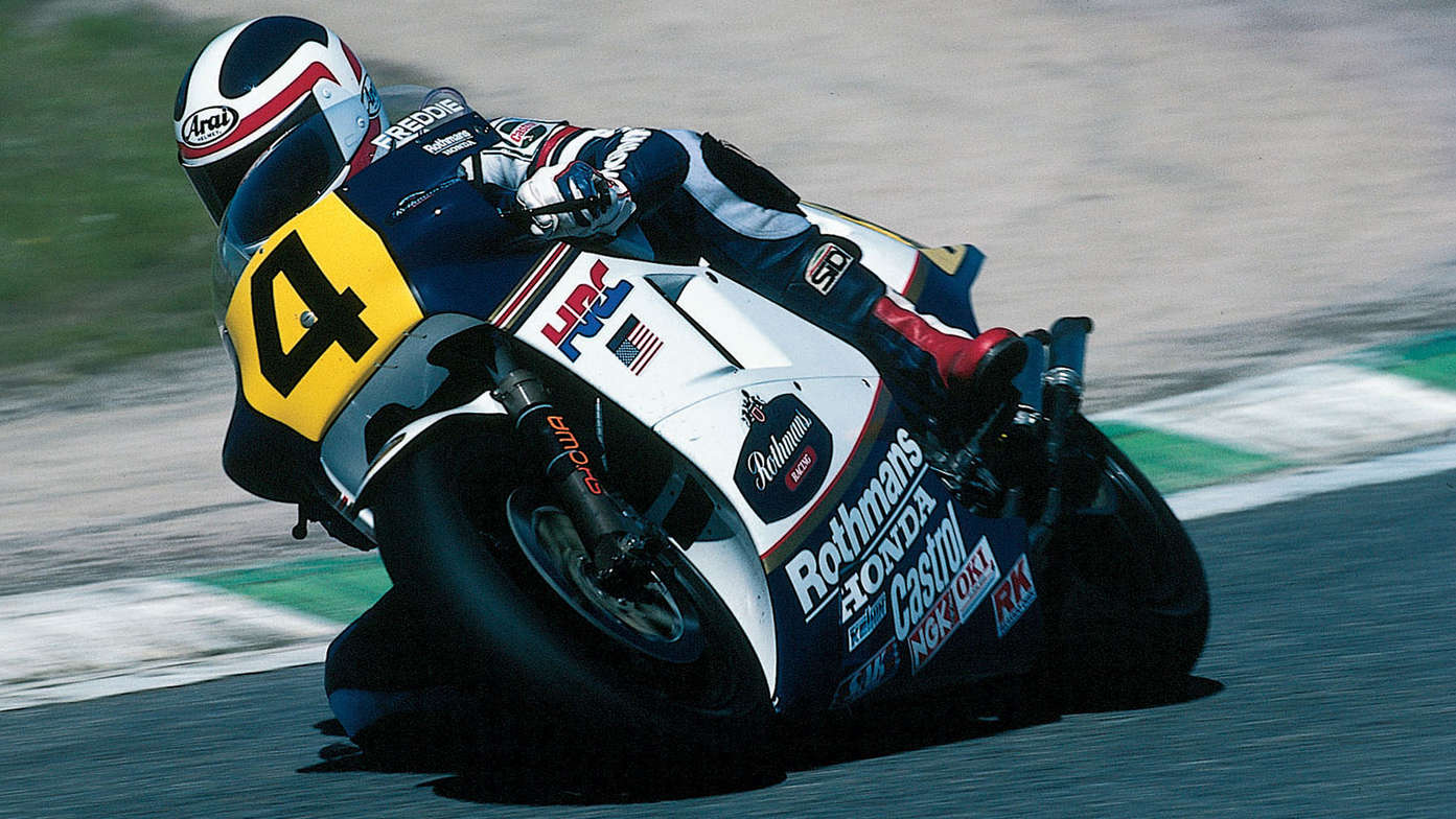 Pohľad spredu na motocykel Honda v zákrute s Freddiem Spencerom na dráhe MotoGP.
