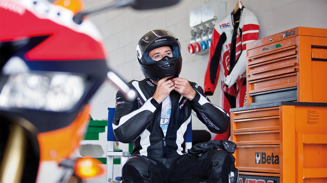 Pretekár MotoGP v motocyklovom oblečení a prilbe.