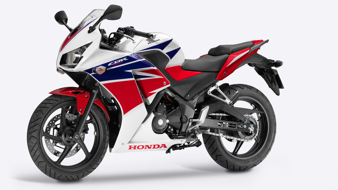 Bočný pohľad na motocykel Honda s červeno-bielo-modrým dizajnom.